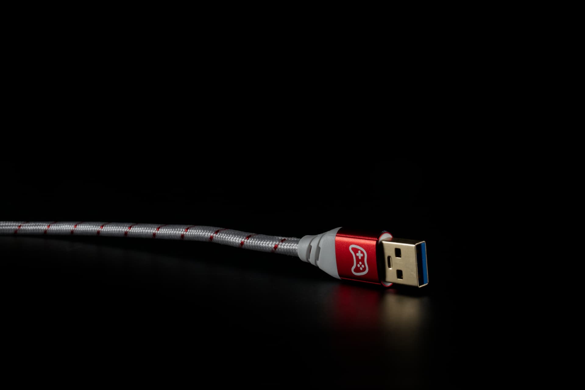 Roter USB-A-Stecker mit Gaming-Signet auf schwarzem Untergrund